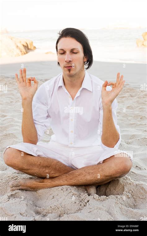 Man Meditating on Beach Stock Photo - Alamy