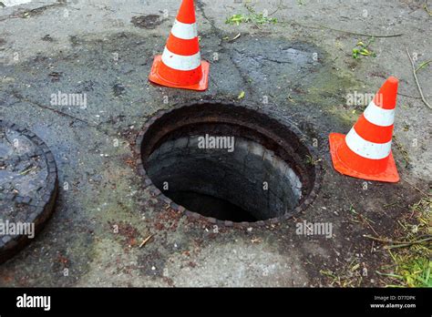 Open manhole cover with cone Stock Photo - Alamy