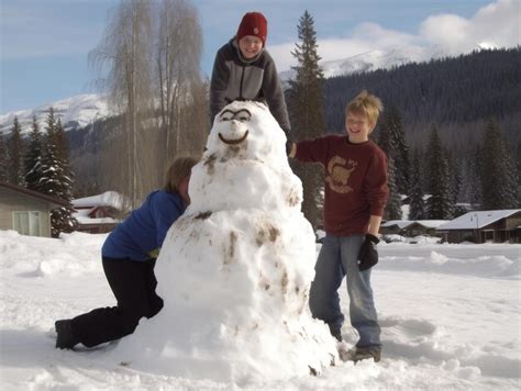 Premium AI Image | Kids building a snowman in winter day