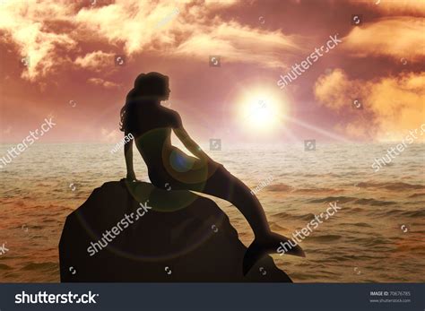 A Mermaid Sitting On The Rock During Sunset Stock Photo 70676785 ...