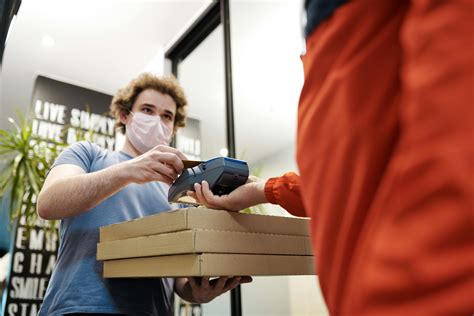 Man Wearing a Face Mask Paying for Pizza Delivery · Free Stock Photo