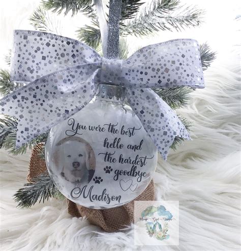 a glass ornament with a dog's photo on it and a bow