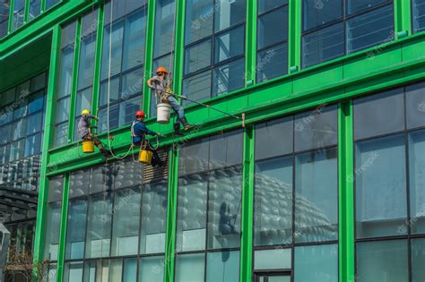 Premium Photo | Window cleaner working on a glass facade in a gondola