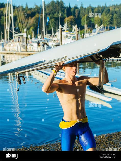 Teenage boy holding sculling boat above head Stock Photo - Alamy