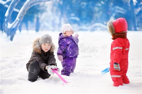 Little Children in Winter Clothes Having Fun in Park at the Snowy ...