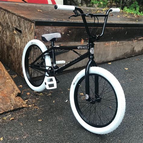 a black and white bicycle parked next to a log