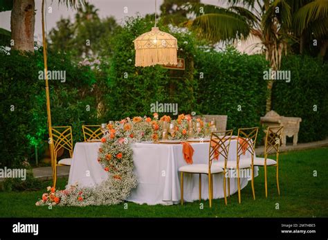 Banquet table near chandelier with light on Stock Photo - Alamy