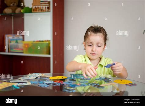 Cute little girl solving puzzles at home Stock Photo - Alamy