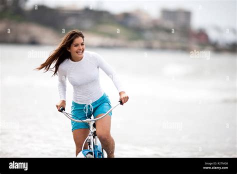 Young woman riding her bike on the beach Stock Photo - Alamy