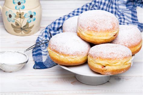 Traditional Polish donuts with powdered sugar on wooden background ...