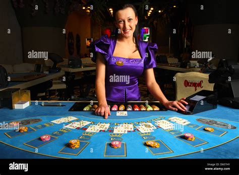 Smiling dealer, croupier showing cards in casino at blackjack table ...