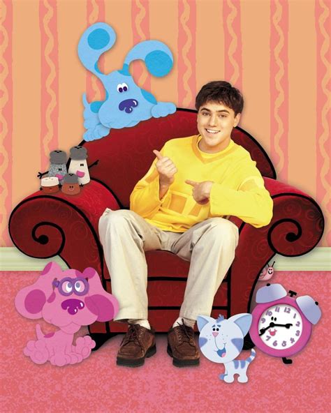 a man sitting on top of a red chair next to stuffed animals and a clock