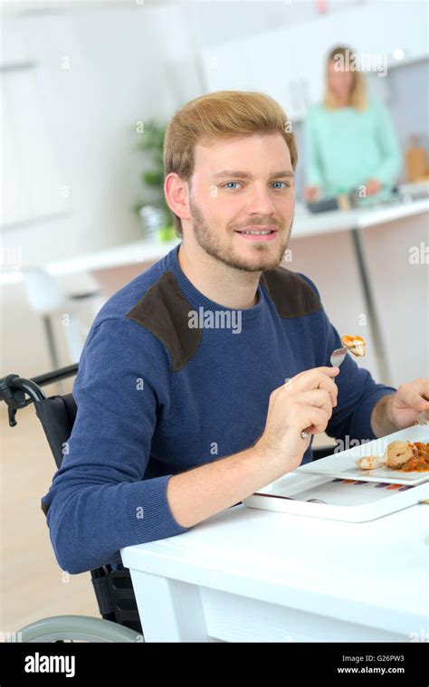 Disabled man sat at the dining table Stock Photo - Alamy