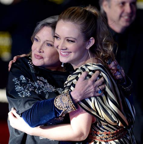 two women hugging each other on the red carpet in front of an audience at a star wars event