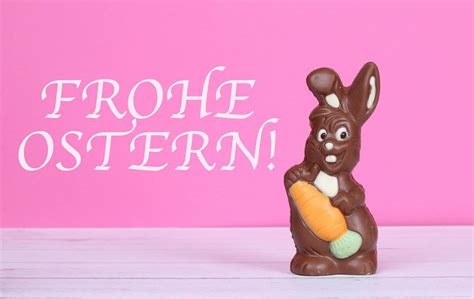 Chocolate easter bunny with Frohe Ostern text on pink background ...