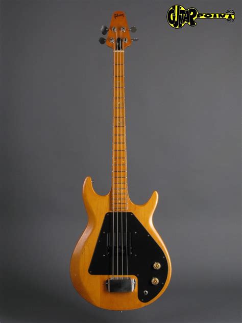 an electric bass guitar is shown against a gray background