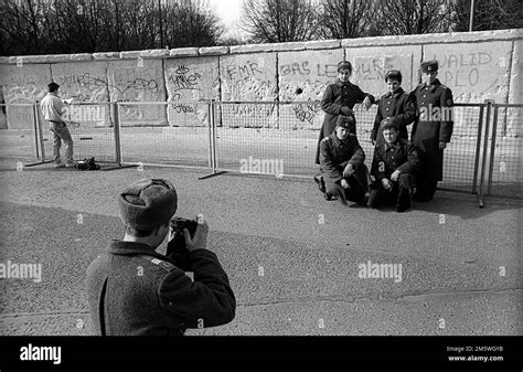 GDR, Berlin, 23. 02. 1990, Soviet (Russian) soldiers taking photos of themselves at the Wall at ...