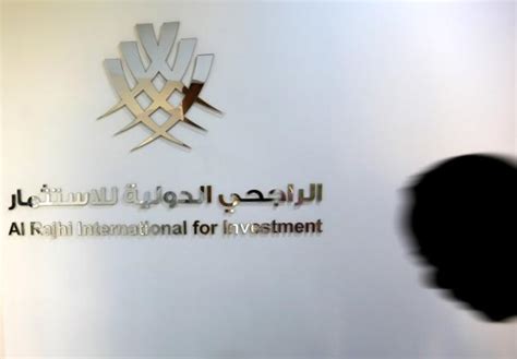 A man walks past the logo of Al Rajhi International for Investment at ...