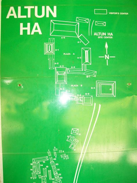 a green sign with white writing on it that says altun ha and features drawings of furniture