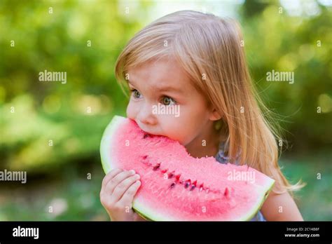 Child eating watermelon in the garden. Kids eat fruit outdoors. Healthy snack for children. 2 ...