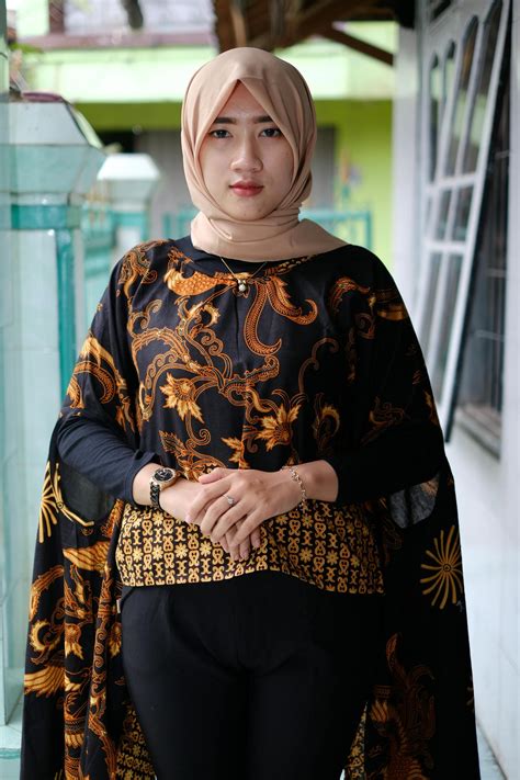 Stylish Muslim woman in hijab standing on terrace · Free Stock Photo