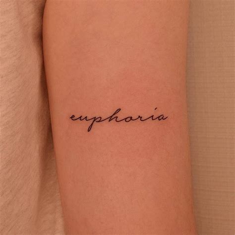 "Euphoria" lettering tattoo on the inner arm.