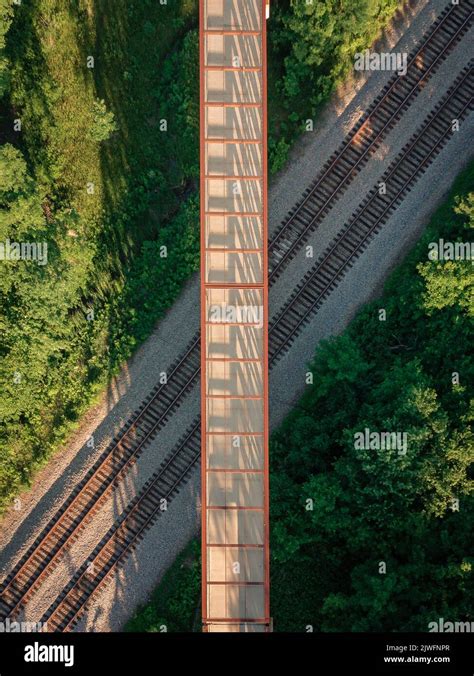 A vertical aerial view of a bridge hanging above train tracks inside a ...