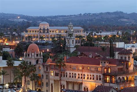 an old building is lit up at night in front of some palm trees and ...