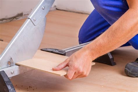 Man Cutting Laminate Floor Boards on Circular Saw, Detail on Hands Holding Wooden Panel Stock ...