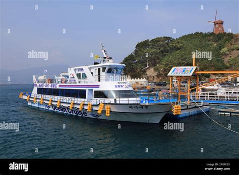 GEOJE, SOUTH KOREA - APRIL 1, 2023: Ocean cruise ship and winmill on Windy Hill, tourist ...