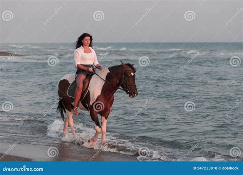 Woman in Summer Clothes Enjoys Riding a Horse on a Beautiful Sandy ...