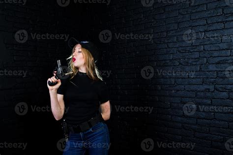 FBI female agent in cap and with gun at studio against dark brick wall. 10496452 Stock Photo at ...