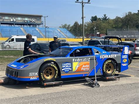 two men working on a race car in a parking lot