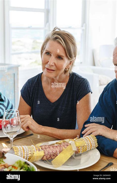 Woman listening attentively at dining table in home party Stock Photo ...