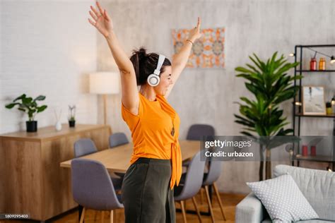 Young Woman Singing And Dancing In The Living Room High-Res Stock Photo ...