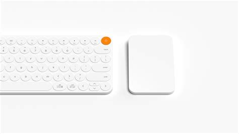 an apple keyboard and mouse sitting next to each other on a white surface with orange buttons