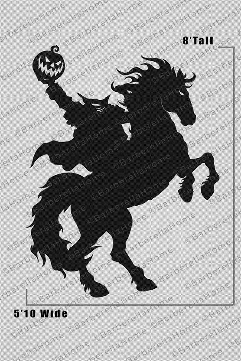 a black and white image of a horse with a pumpkin in its mouth, on top of