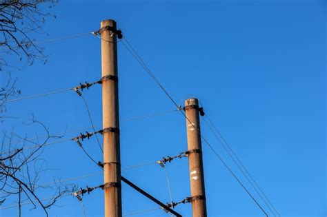 Premium Photo | Electric pole with a linear wire against the blue sky close-up power electric pole