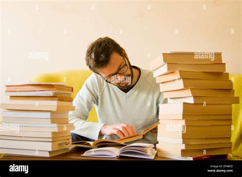 Man studying with a pile of books in front of him Stock Photo: 82458389 ...