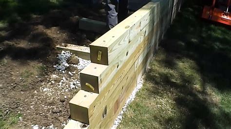 Step-by-step HOW TO video of building a timber wall with 6" x 6" x 8-foot treated timbers ...