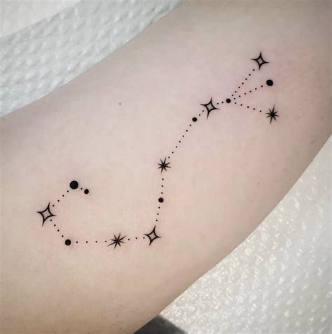 a small star tattoo on the arm with stars and dots in it's center