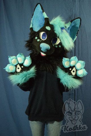 a person in a black shirt and blue furry animal costume standing next to a curtain