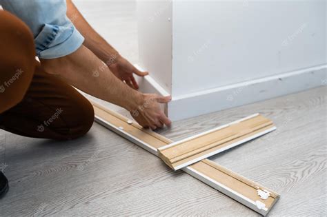 Premium Photo | Installing the new skirting board after changing the ...