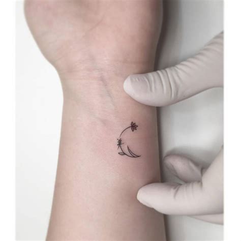 Minimalist flower moon tattoo on the wrist.