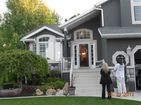 dark grey stucco house with white trim - Zena Damron