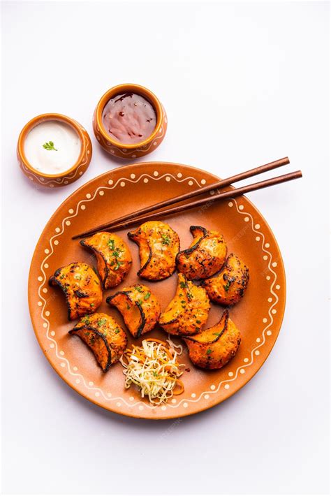 Premium Photo | Tandoori momo veg or non veg in red and cream sauce ...