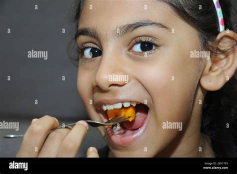 India, 25, 2015 -Cute little Indian little girl eating healthy mango that contain glucose can ...