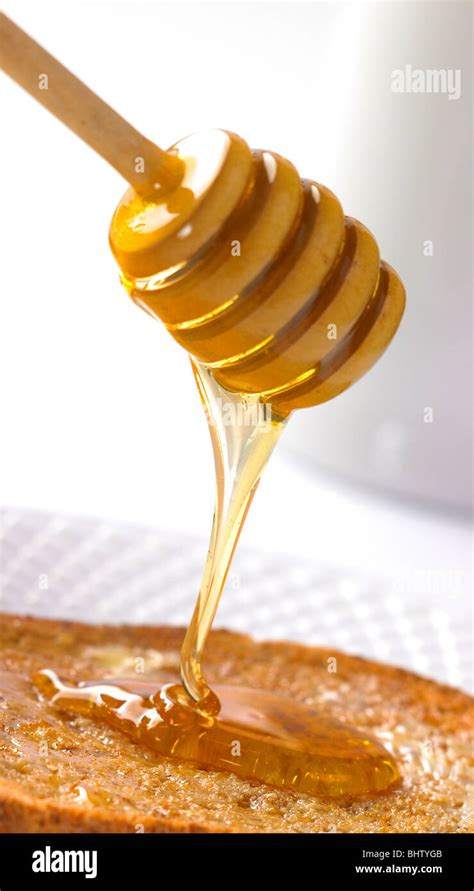 honey stick dripping honey onto toast Stock Photo - Alamy