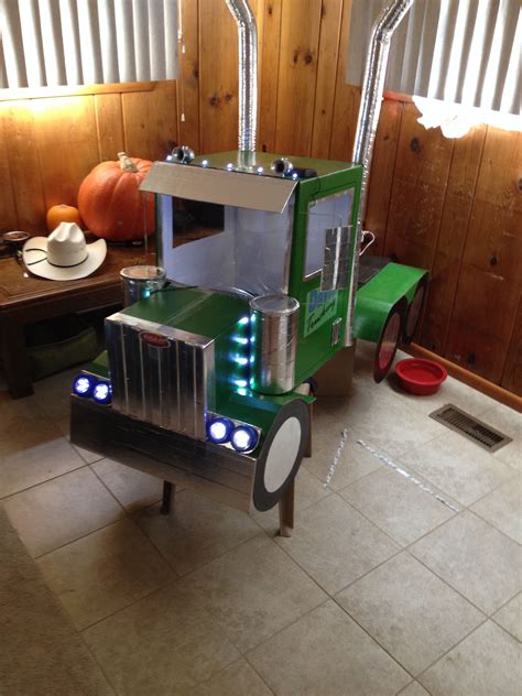 a green truck with lights on sitting in the middle of a room next to a window