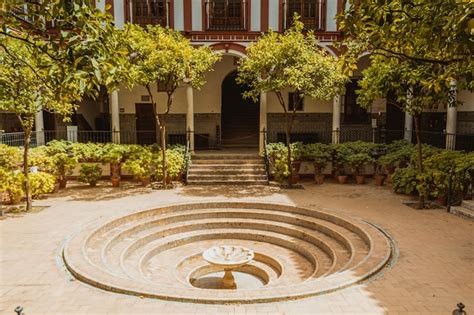 Premium Photo | A courtyard with a fountain in front of it that has a ...